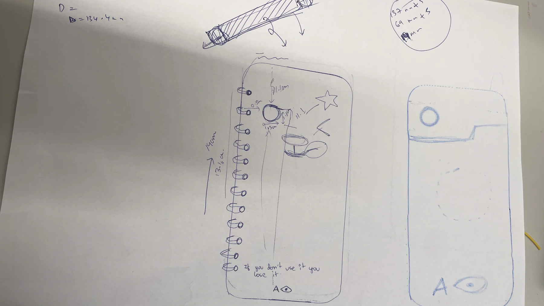Pen sketch of the device with measurements, a ring binding, a camera eye and the line: If you don’t use it, you lose it
