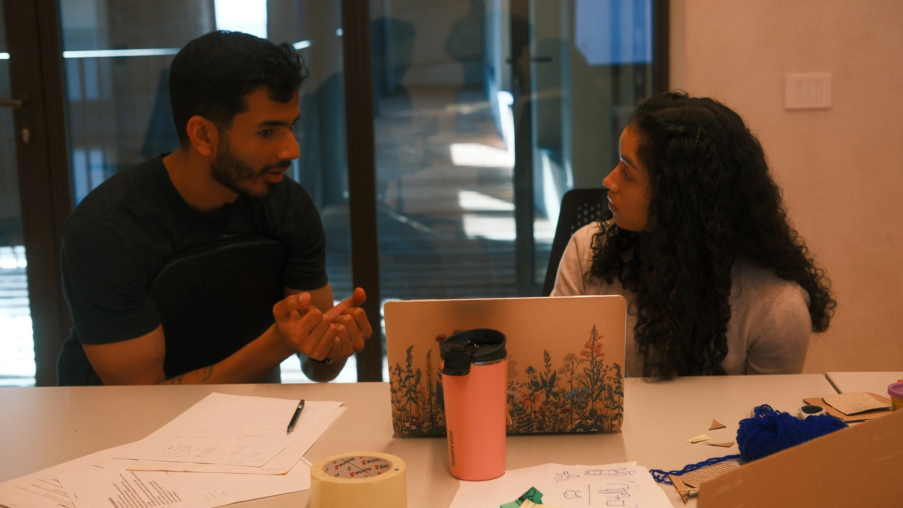 Two teammates discussing the concept at a table covered in sketches