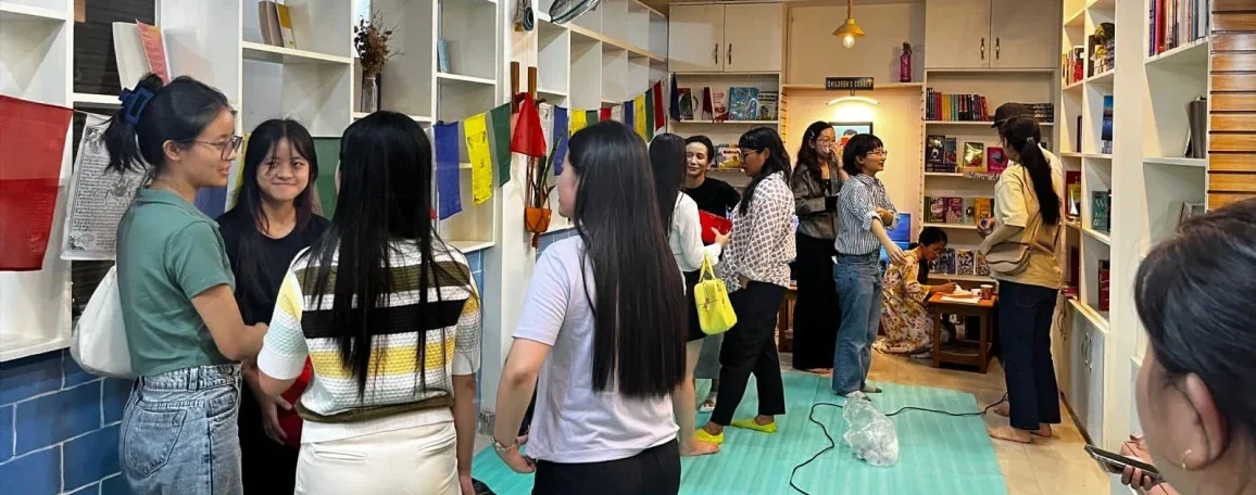 People talking and mingling among bookshelves at the first CuriousBeans event