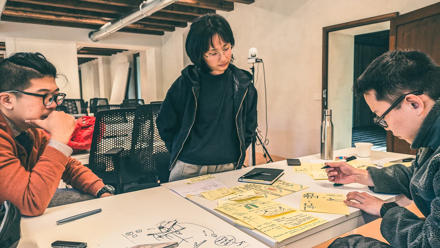 The team planning around a table covered in sticky notes and sketches