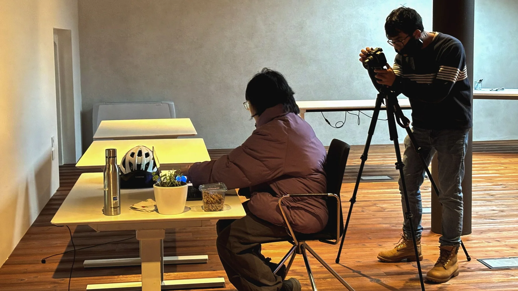 Filming a scene for the video, with one teammate behind a camera on a tripod