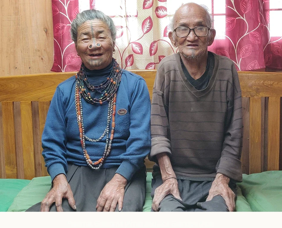 My paternal grandma (Ama), with facial tattoos, nose plugs and bead necklaces, beside my late grandpa (Aba)