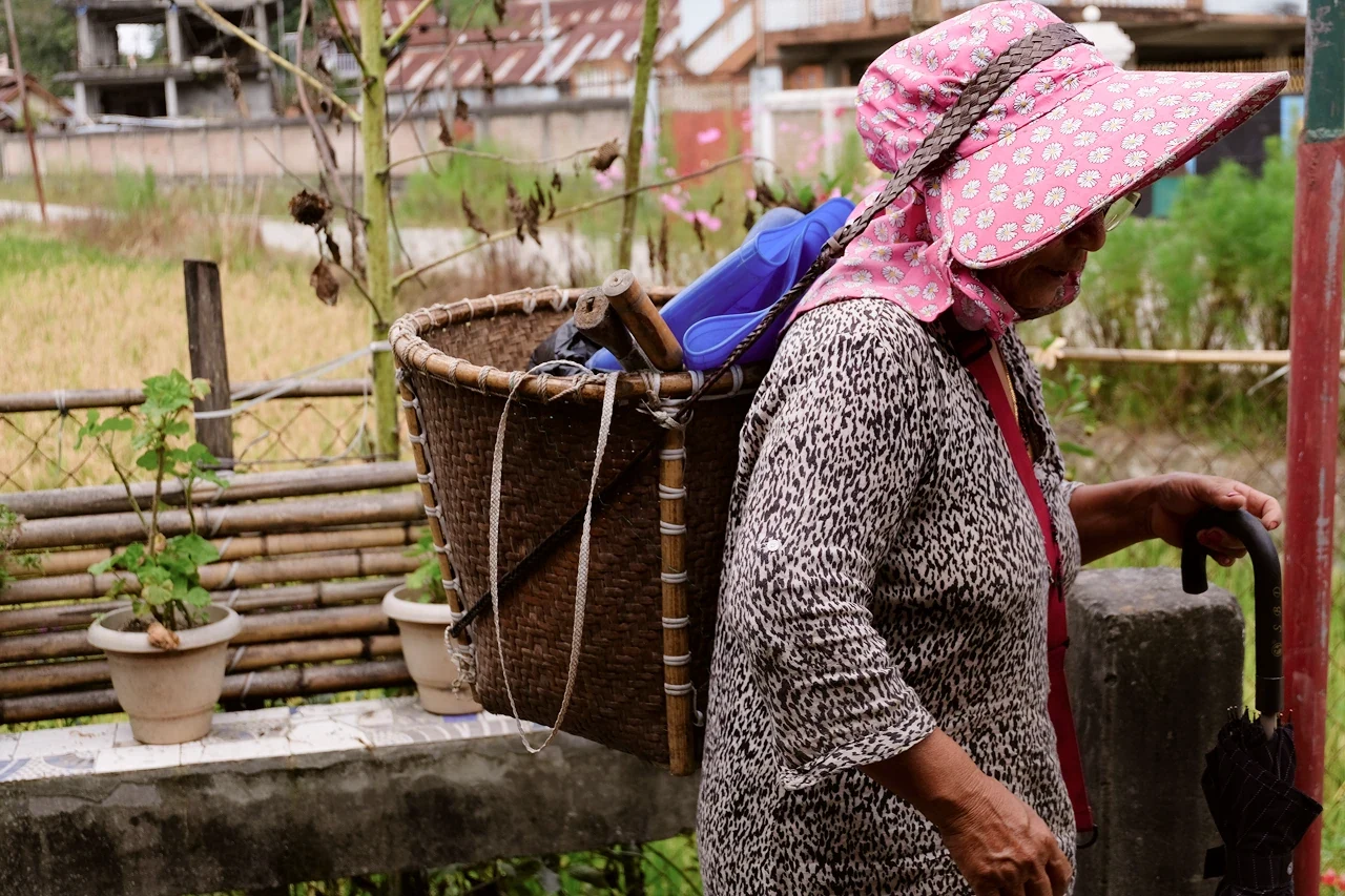 An everyday community member in Ziro carrying a woven bamboo basket on her back