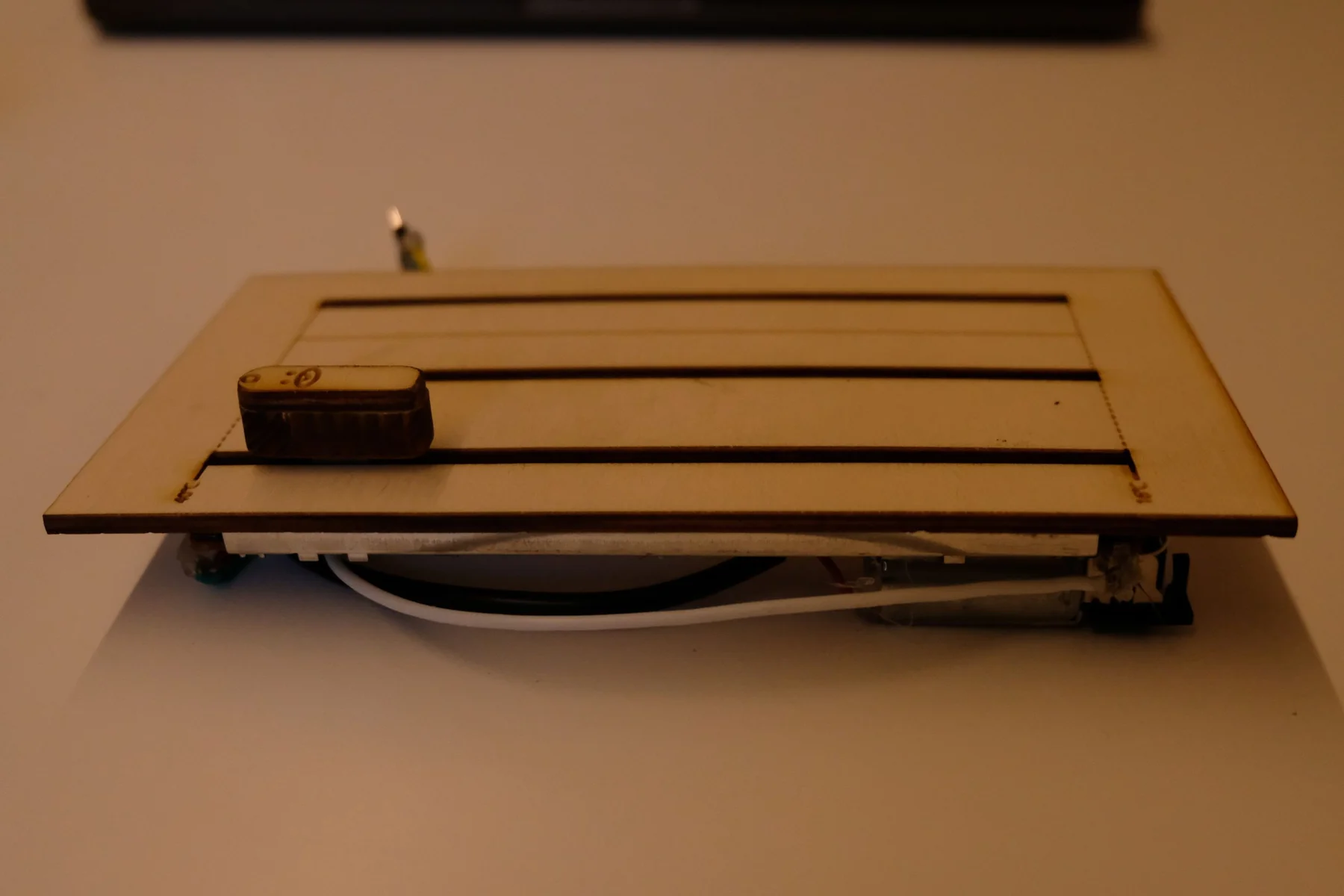 An early laser-cut wooden prototype with three fader slots